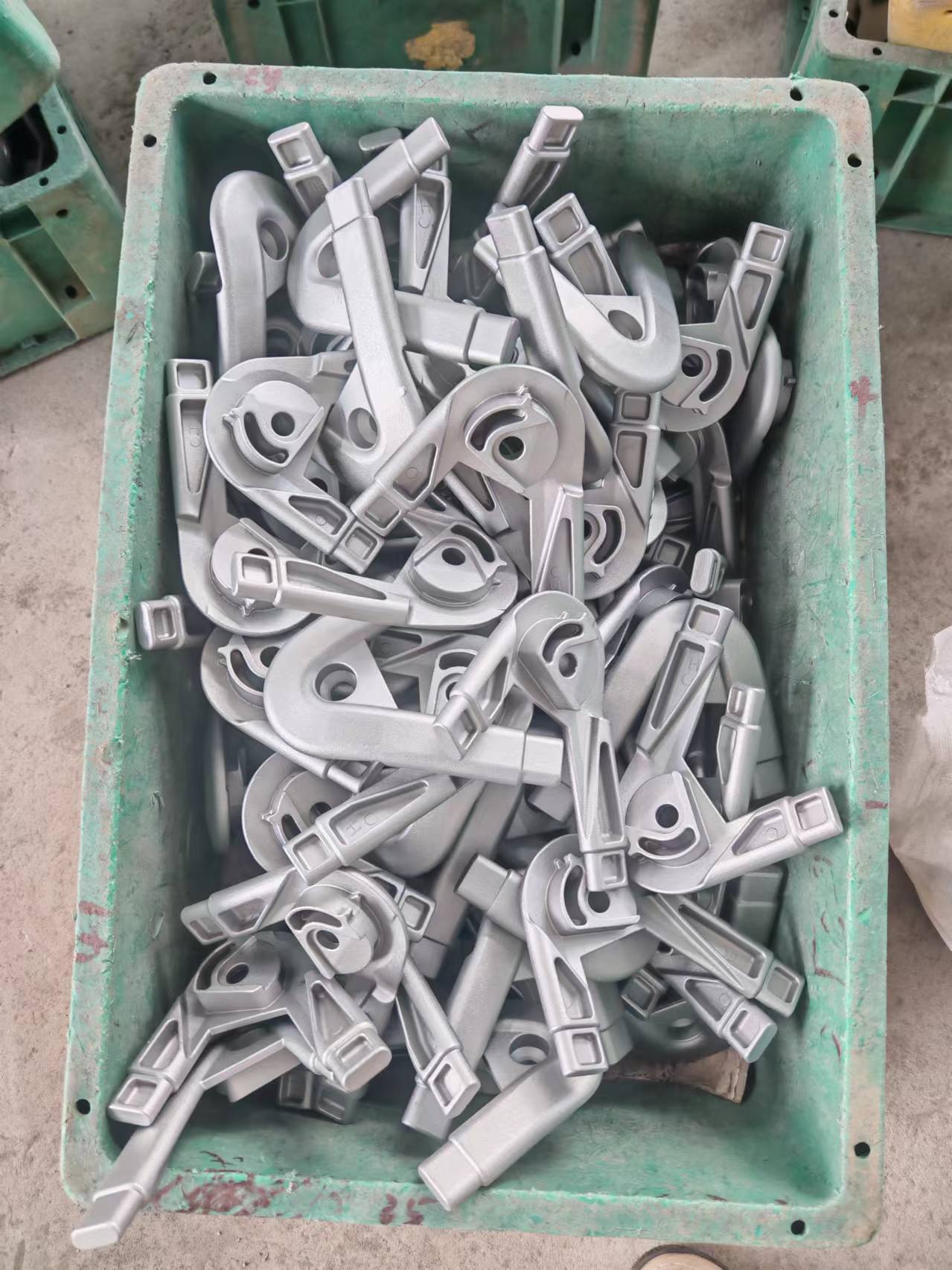 A floor setting featuring a basket containing various metal parts from carbon steel investment casting