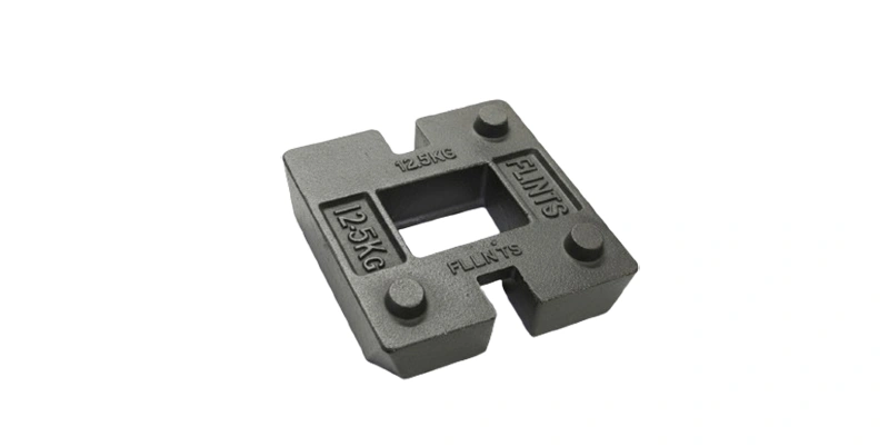 A black cast iron block labeled with the letter h, used as a counterweight in various applications