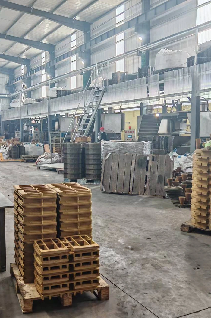 a factory interior filled with wooden pallets and crates, showcasing a sand casting operation in progress