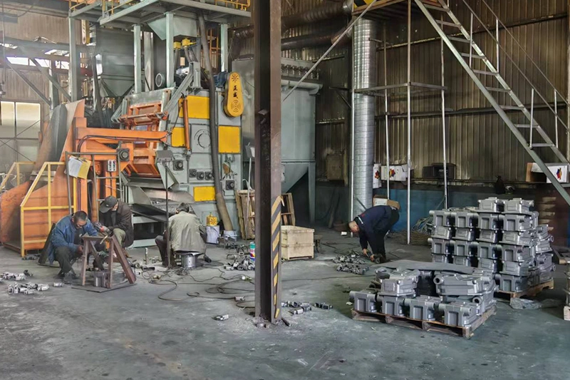 a factory scene showing workers engaged in clean sand casting of metal components