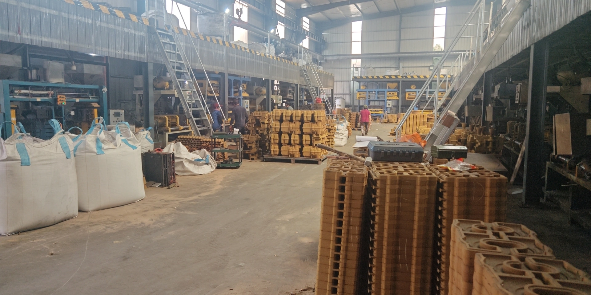 a warehouse filled with wooden pallets and various items, including materials for sand casting