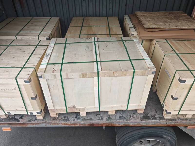 A truck loaded with wooden boxes containing iron casting parts, parked on a construction site